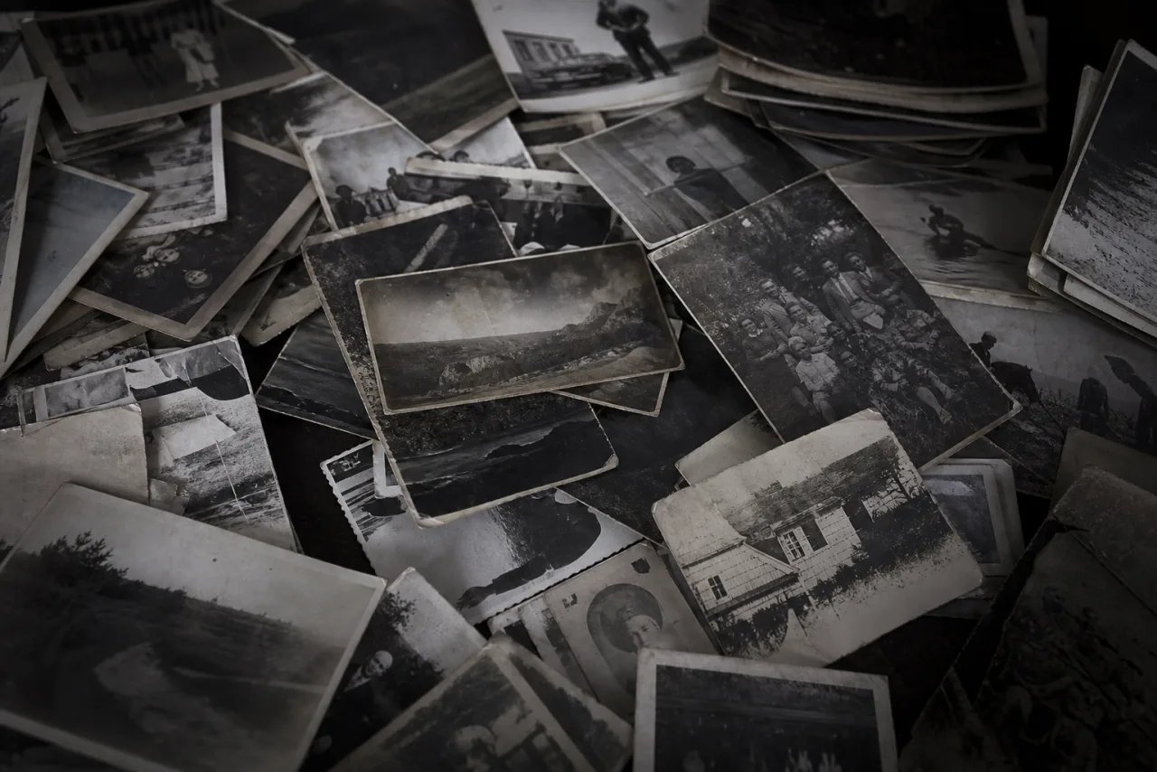 A cluttered pile of scattered black-and-white photographs